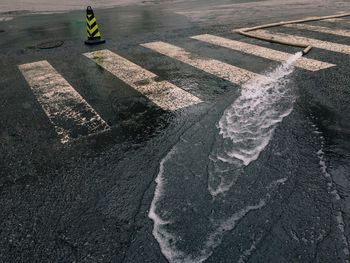 High angle view of water flowing through pipe on road