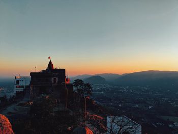 Buildings in city against sky during sunset