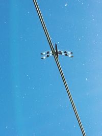 Low angle view of wind turbine against clear blue sky