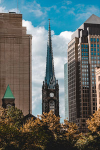 Low angle view of buildings against cloudy sky