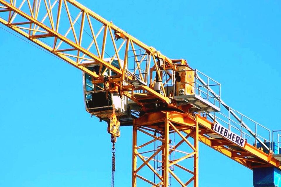 low angle view, clear sky, blue, built structure, connection, copy space, architecture, metal, communication, technology, transportation, metallic, construction site, day, outdoors, engineering, electricity pylon, no people, cable, sky