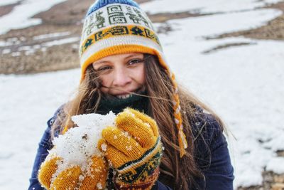 Portrait of smiling woman holding snow