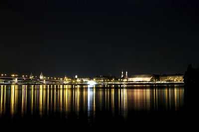 Illuminated city at waterfront at night