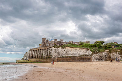 Scenic view of beach against cloudy sky