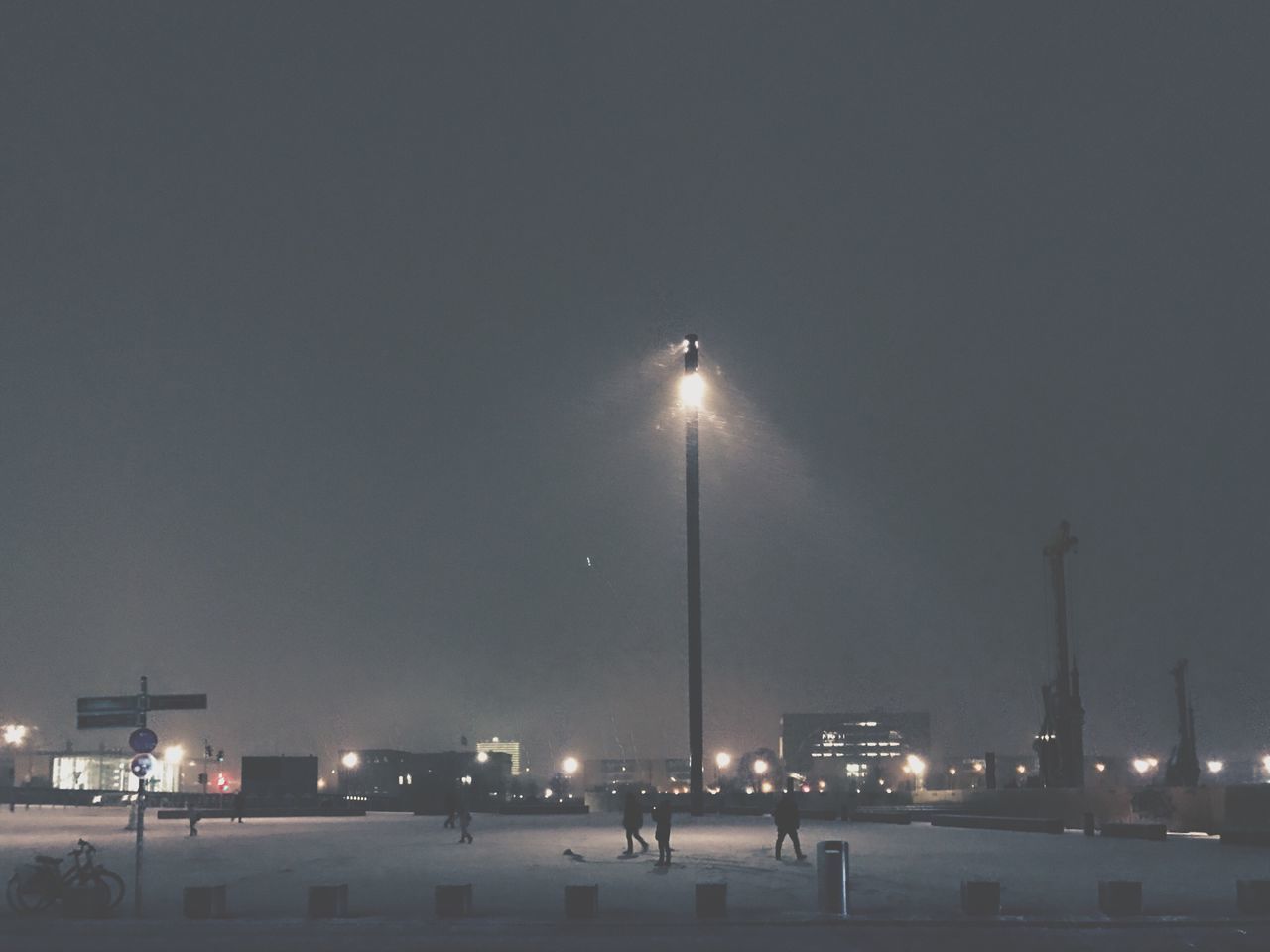 ILLUMINATED STREET LIGHTS AGAINST SKY