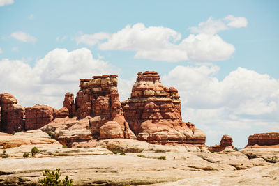 Layered red sandstone towers on a sunny day in the maze utah