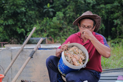 Full length portrait of man sitting outdoors