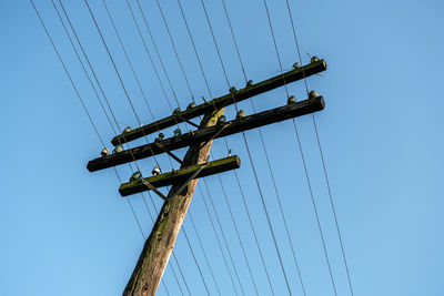 Low angle view of electricity pylon against sky