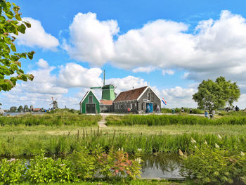 Houses by buildings against sky