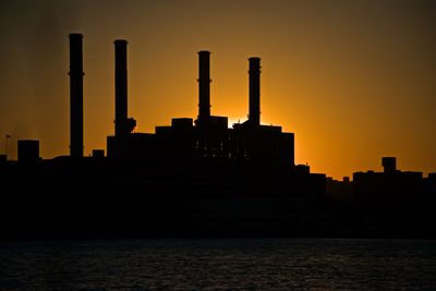 Silhouette buildings against sky during sunset