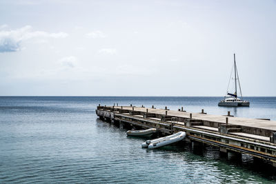 Sailboats moored on sea against sky