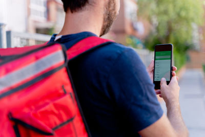 Rear view of man using mobile phone