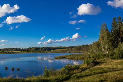 Calm countryside lake against blue sky