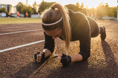 Full length of woman exercising in stadium