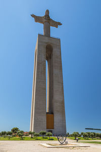 Low angle view of cross sculpture against clear sky