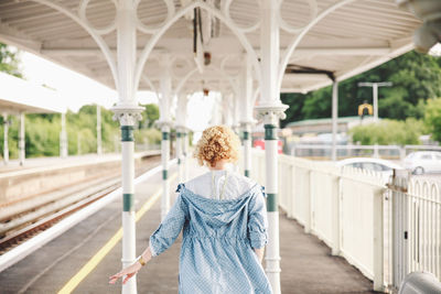 Rear view of woman standing against wall