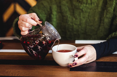 Man holding coffee cup on table