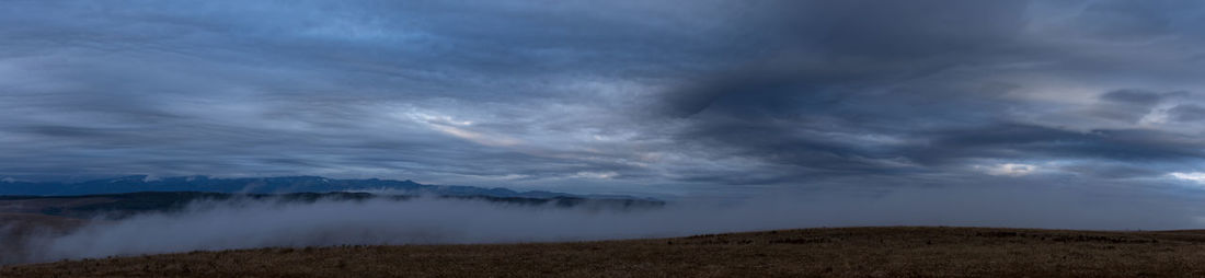 Scenic view of land against sky at dusk