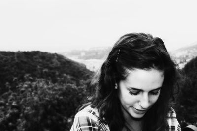 Portrait of a smiling young woman against sky