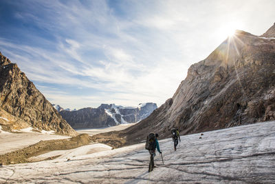 Panoramic view of people walking on mountain against sky