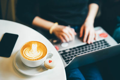 Coffee on table with woman in background