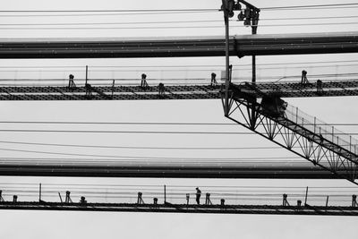 People on bridge against sky