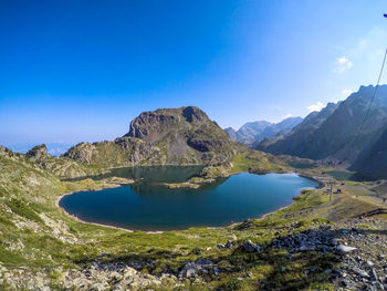 Scenic view of lake and mountains against blue sky