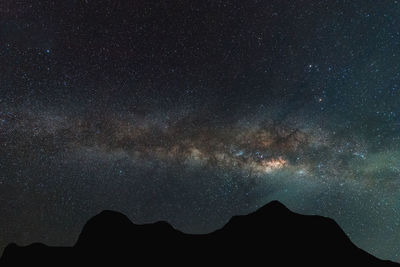 Silhouette mountain against sky at night