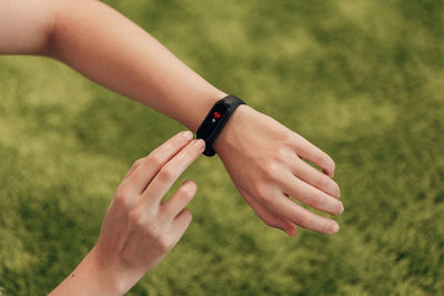 Close-up of woman hand holding grass against blurred background