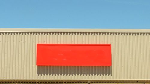 Low angle view of red building against blue sky