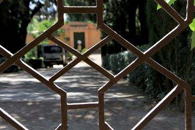 Close-up of metal fence against trees