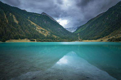 Scenic view of lake by mountains against sky