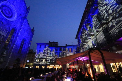 People in illuminated city at night