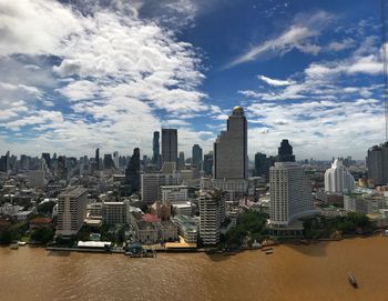 View of cityscape against cloudy sky