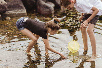 Brother and sister fishing in sea during vacation