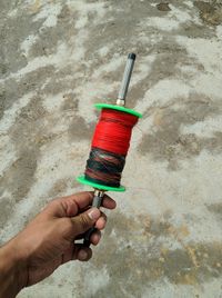 Close-up of hand holding umbrella against wall