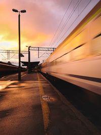 Train on street against sky during sunset