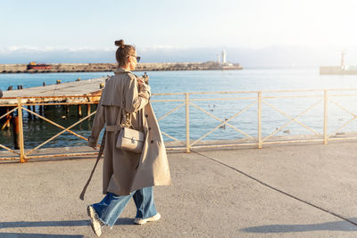 Full length of woman walking by sea