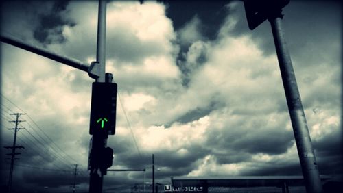 Low angle view of street light against cloudy sky