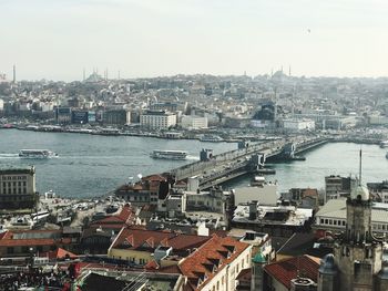High angle view of cityscape by sea against sky