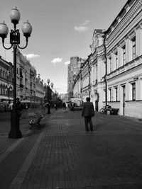 People walking on street amidst buildings in city