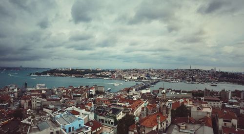 High angle view of city by sea against sky