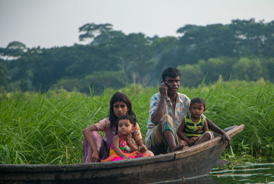 People on water against plants