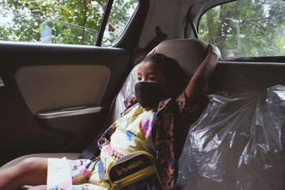 Scenic view of a young girl sitting in car