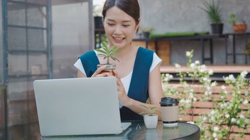 Smiling young woman using mobile phone