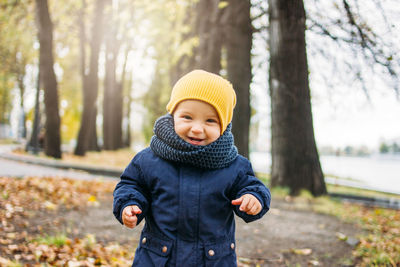 Portrait of cute baby boy standing in park