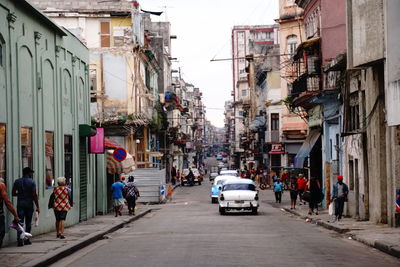 People on street amidst buildings in city