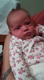 Portrait of cute baby girl lying on bed at home