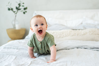 Cute baby boy sleeping on bed at home