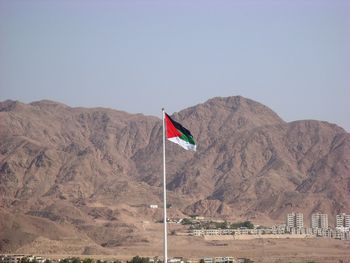 Flag on mountain against clear sky